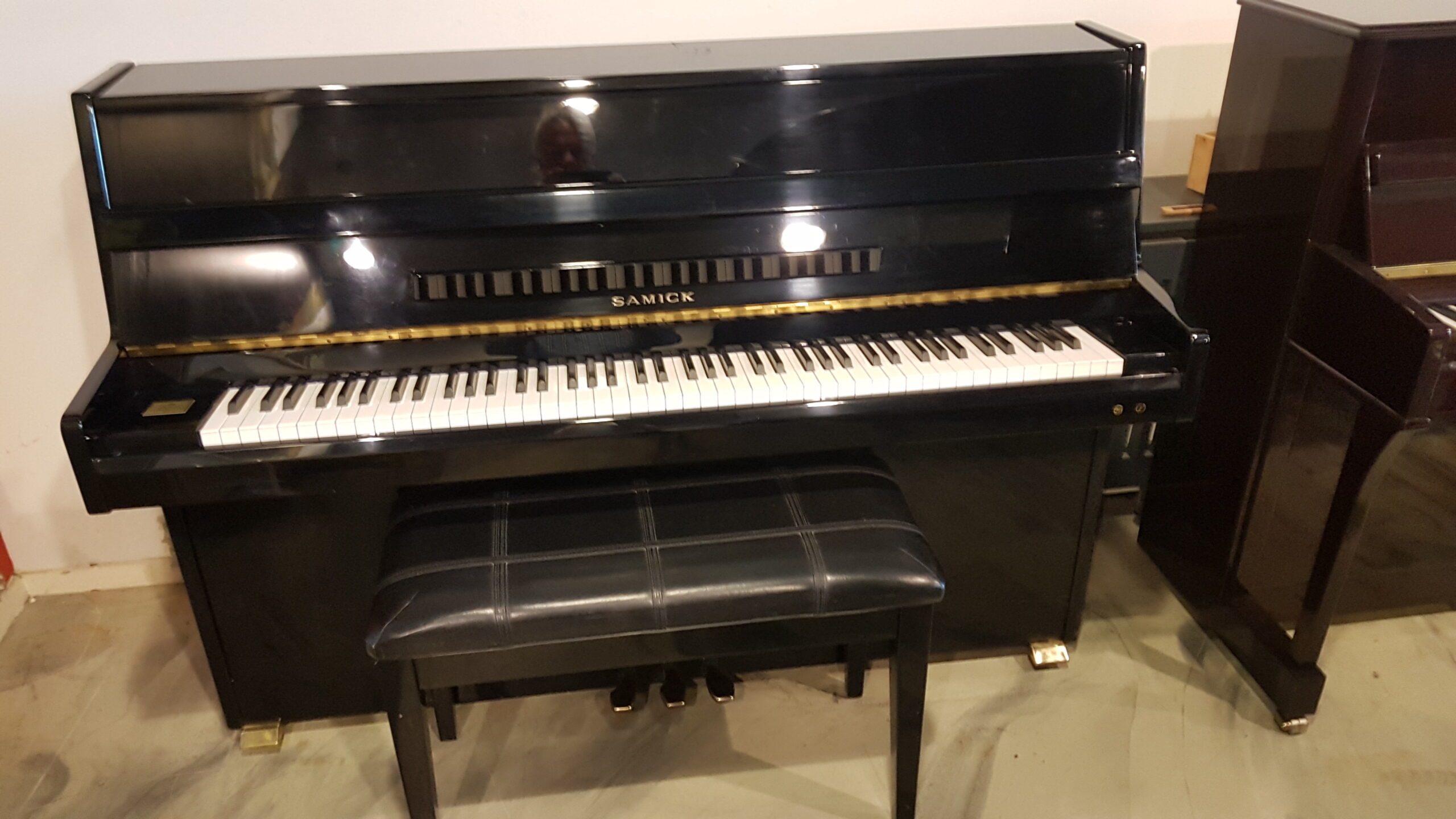 Gebruikte piano Samick 104 zwart hoogglans met studiepadaal.  €  1090,-